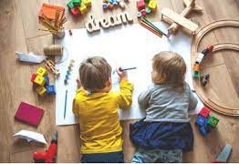 Two children lying over a big blank piece of paper, dream written at the top, one about to draw, the younger one looking at him. This aims to signify the family therapy and parenting support you could receive from a Clinical Psychologist in Sheffield.